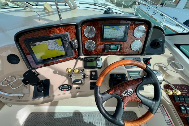 Slide: The Image of Helm of 2005 Sea Ray 500 Sundancer with navigation screens and wooden steering wheel. - 11