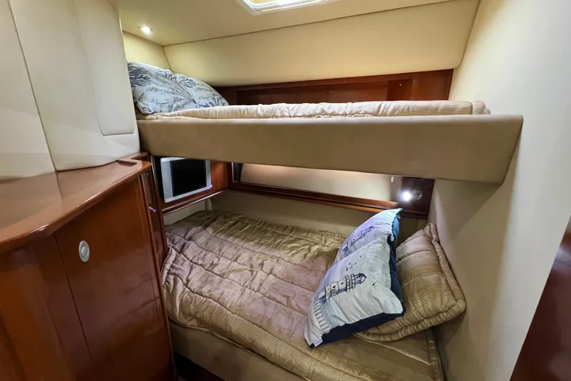 Slide: The Image of 2005 Sea Ray 500 Sundancer cabin with cozy bunk beds and wooden cabinetry. - 23
