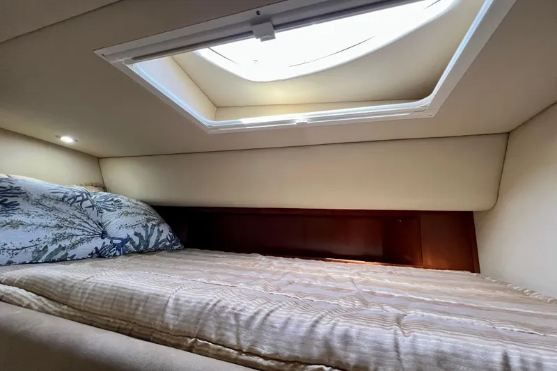 Slide: The Image of Cozy cabin interior of 2005 Sea Ray 500 Sundancer with skylight and bedding. - 24