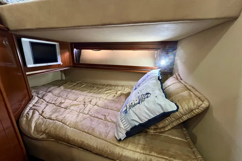 Slide: The Image of Cozy cabin interior of 2005 Sea Ray 500 Sundancer with bed and small TV. - 25