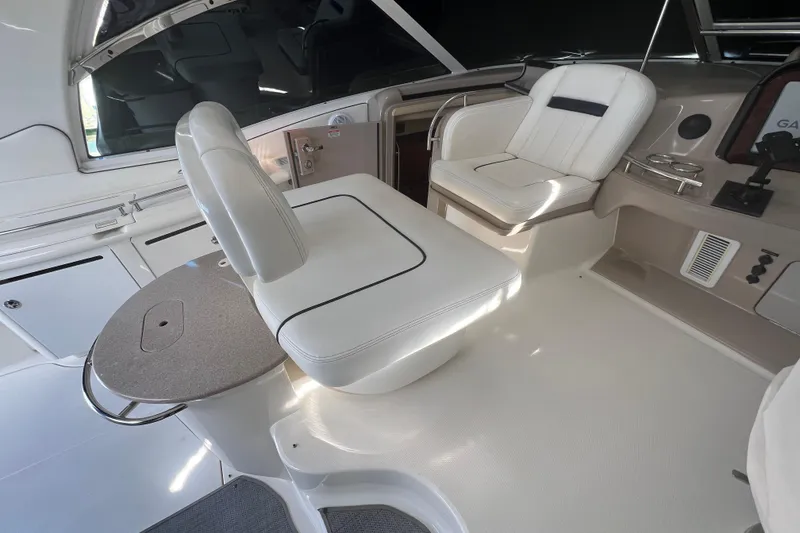 Slide: The Image of 2005 Sea Ray 500 Sundancer cockpit with white seating and control panel. - 28