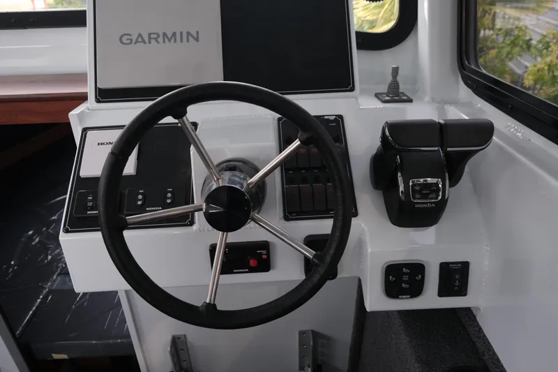 Slide: The Image of 2026 Hewescraft 270 Pacific Explorer helm with Garmin navigation and Honda controls. - 11