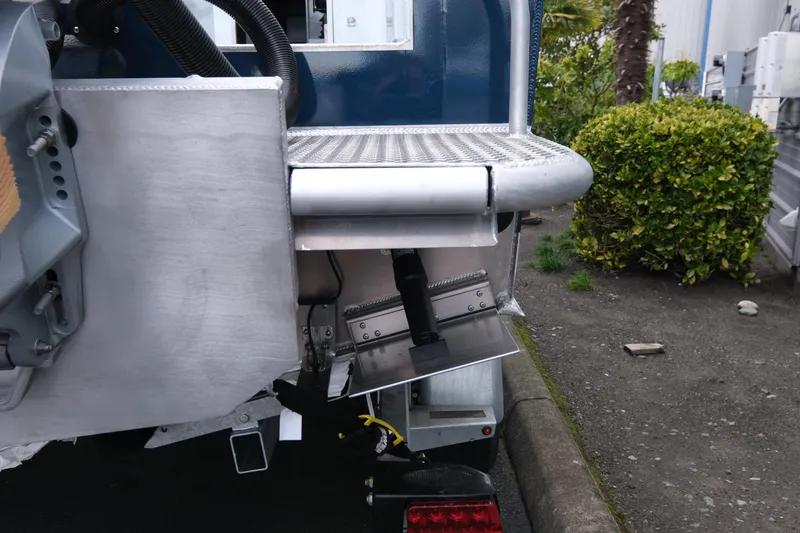 Slide: The Image of Rear view of 2026 Hewescraft 270 Pacific Explorer boat with trim tab and metal platform. - 20