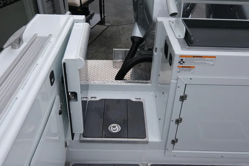 Slide: The Image of 2026 Hewescraft 270 Pacific Explorer boat deck with storage compartments and safety warnings. - 21