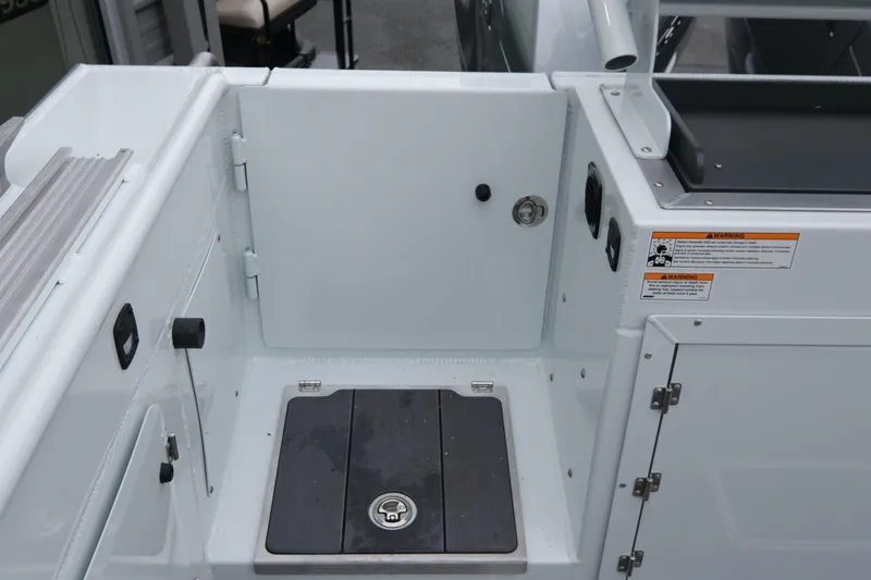 Slide: The Image of 2026 Hewescraft 270 Pacific Explorer boat deck with storage compartment and safety warnings. - 22