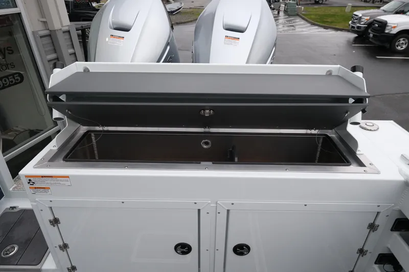 Slide: The Image of 2026 Hewescraft 270 Pacific Explorer boat with open storage compartment and dual engines. - 24