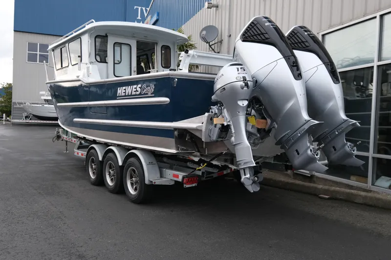 Slide: The Image of 2026 Hewescraft 270 Pacific Explorer boat on trailer with dual outboard motors. - 3