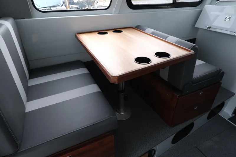 Slide: The Image of 2026 Hewescraft 270 Pacific Explorer interior with dining table and seating. - 8