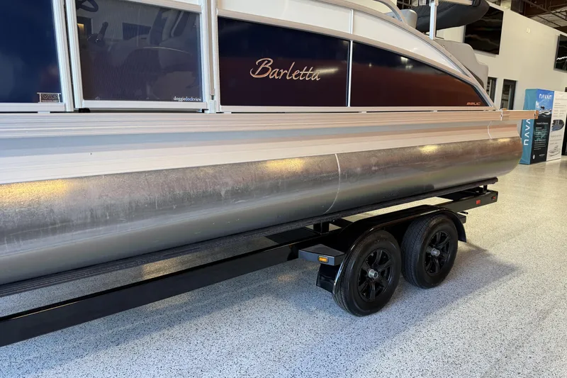 Slide: The Image of 2024 Barletta Cabrio C22UC pontoon boat with 200 V6 engine, under sunny skies. - 2