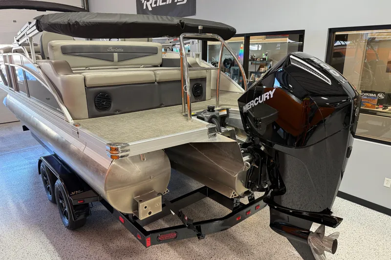 Slide: The Image of 2024 Barletta Cabrio C22UC pontoon boat with gray seating and canopy in showroom. - 6