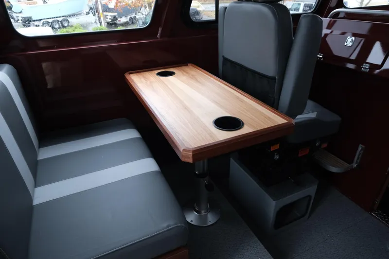 Slide: The Image of Interior of 2026 Hewescraft 240 Pacific Cruiser with seating and wooden table. - 11