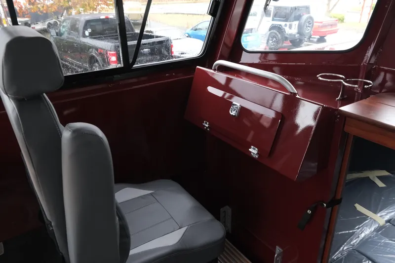 Slide: The Image of Interior of 2026 Hewescraft 240 Pacific Cruiser with gray seating and maroon paneling. - 17