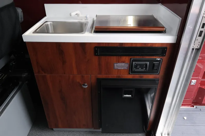 Slide: The Image of 2026 Hewescraft 240 Pacific Cruiser interior kitchenette with sink and storage. - 18