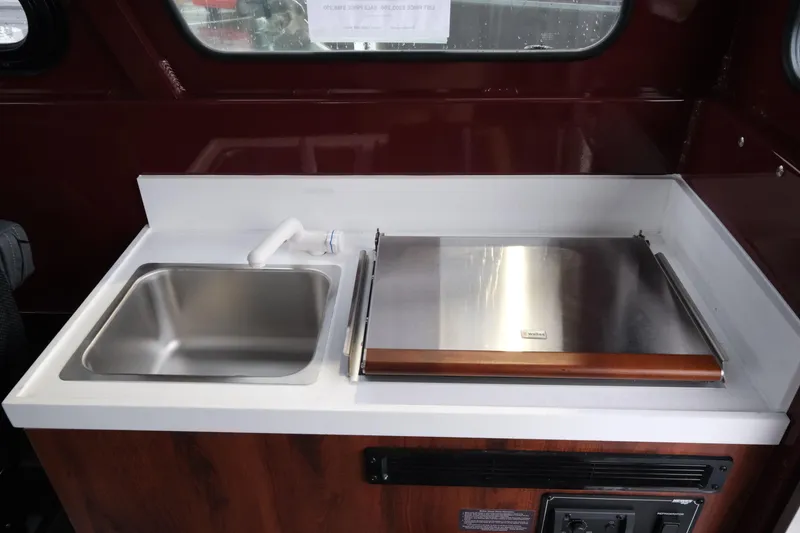 Slide: The Image of Interior of 2026 Hewescraft 240 Pacific Cruiser with sink and stove. - 19