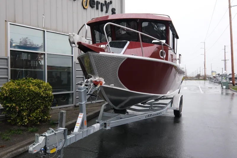 Slide: The Image of 2026 Hewescraft 240 Pacific Cruiser on trailer, parked outside a building. - 3