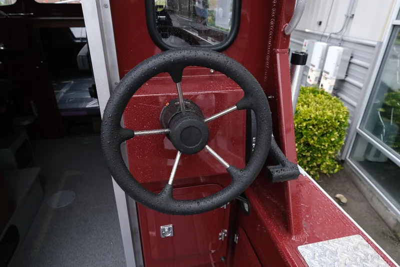 Slide: The Image of Steering wheel of 2026 Hewescraft 240 Pacific Cruiser, wet with raindrops. - 9