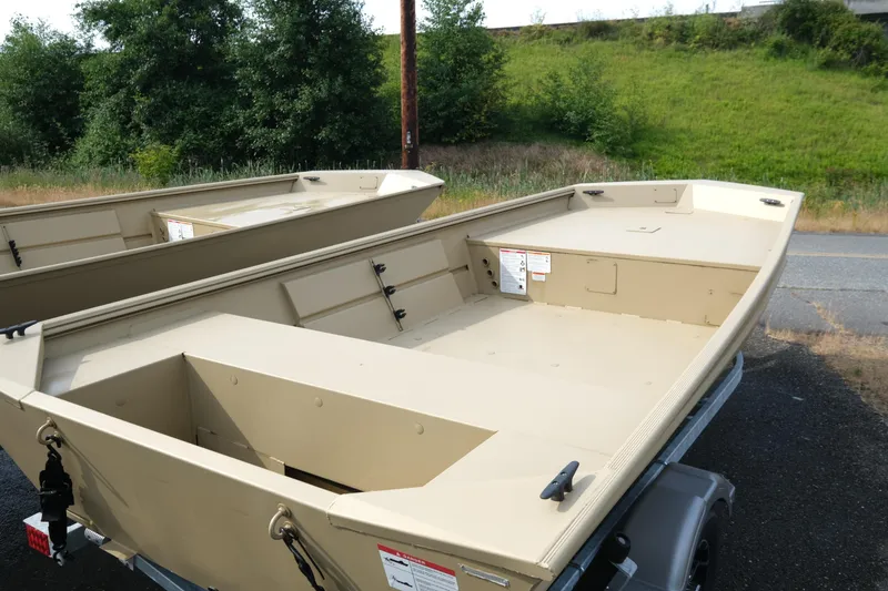 Slide: The Image of 2025 Crestliner 1660 Retriever boat on trailer, parked outdoors near greenery. - 4