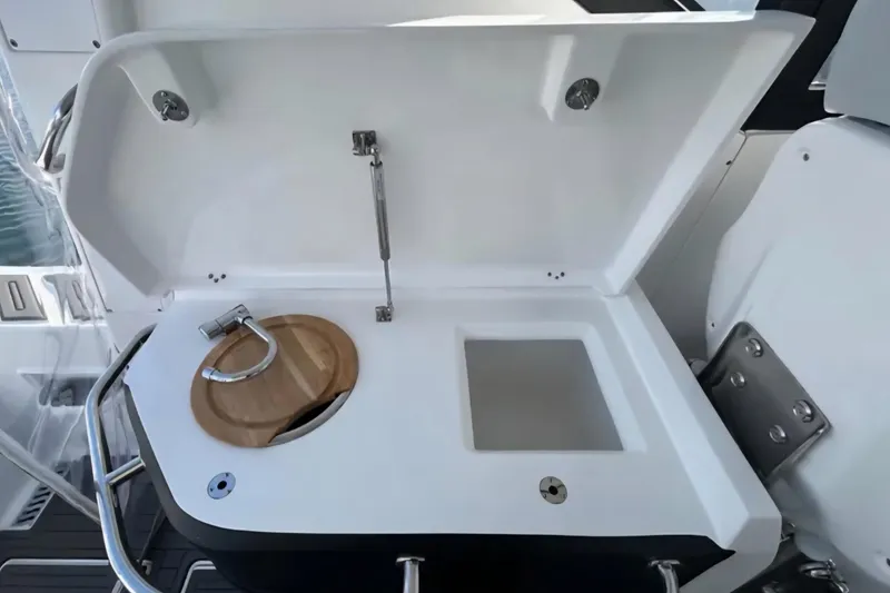 Slide: The Image of 2024 Flexboat 680 Explorer sink and storage area with open lid. - 12