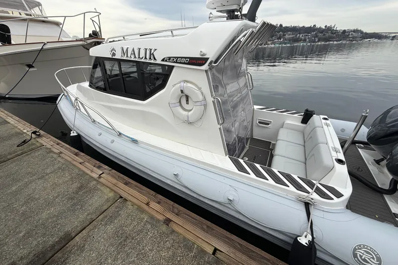 Slide: The Image of 2024 Flexboat 680 Explorer docked, featuring sleek design and spacious seating. - 26