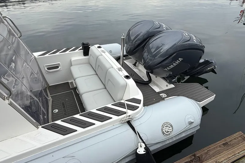 Slide: The Image of 2024 Flexboat 680 Explorer with Yamaha engines, docked on calm water. - 28