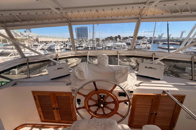 Slide: The Image of 1984 Hartman-Palmer 60 Flush Deck Motor Yacht helm with marina view. - 2