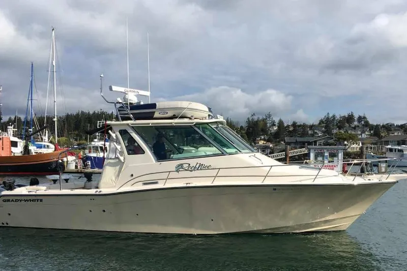 The Image of 2016 Grady-White Express 370 boat docked in a marina, surrounded by other vessels. - 1