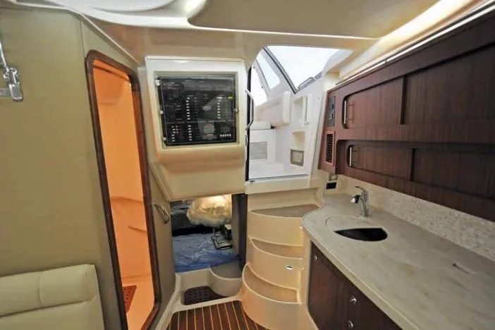 Slide: The Image of Interior of 2016 Grady-White Express 370 boat, featuring a compact kitchen and control panel. - 8