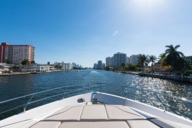 Slide: The Image of Bow view from 2022 Princess Y85 yacht cruising through a sunny urban waterway. - 20