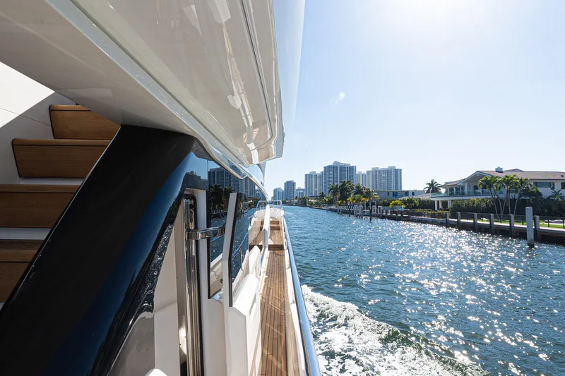 Slide: The Image of Luxurious 2022 Princess Y85 yacht cruising along a sunny waterfront cityscape. - 22