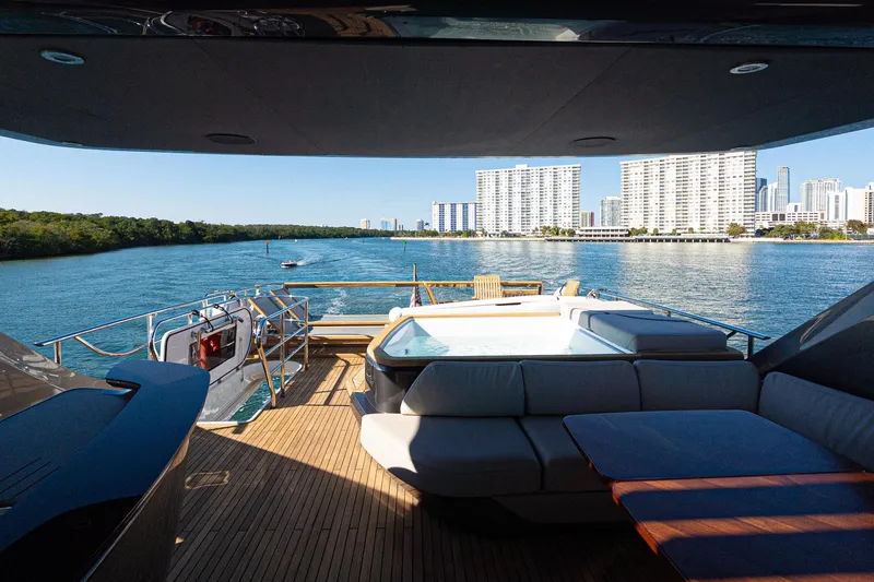 Slide: The Image of Luxurious 2022 Princess Y85 yacht deck with hot tub, overlooking city skyline and waterway. - 23