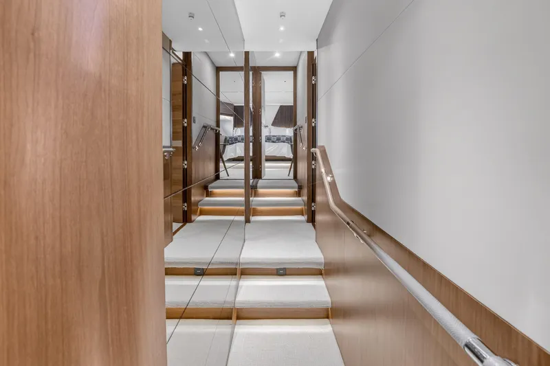 Slide: The Image of Luxurious interior staircase of 2022 Princess Y85 yacht, featuring sleek wood paneling and modern design. - 55
