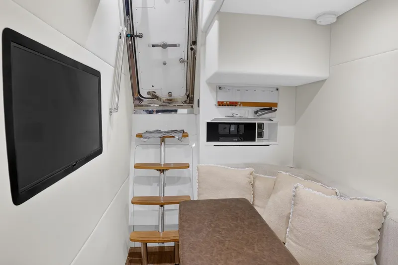 Slide: The Image of Luxurious interior of 2022 Princess Y85 yacht with TV, seating, and ladder access. - 67