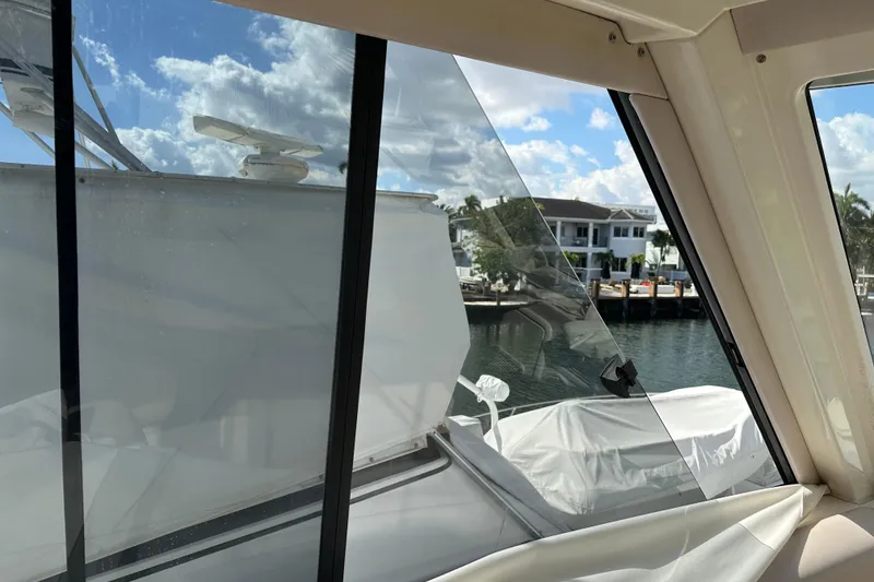 Slide: The Image of 2009 Riviera 47 Enclosed Flybridge Series II, view from interior, overlooking marina and waterfront homes. - 65