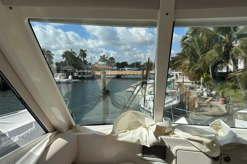 Slide: The Image of View from 2009 Riviera 47 Enclosed Flybridge, overlooking marina with palm trees and boats. - 66