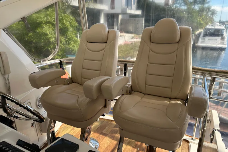Slide: The Image of Luxurious beige captain chairs on 2009 Riviera 47 Enclosed Flybridge Series II yacht. - 70