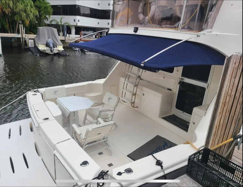 Slide: The Image of 2009 Riviera 47 Enclosed Flybridge yacht docked with seating area. - 74
