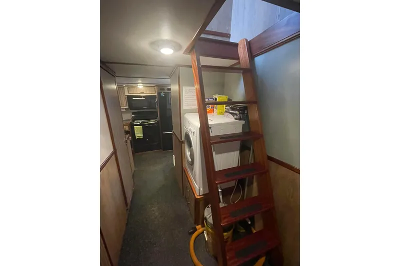 Slide: The Image of Interior of 1973 Custom 58’ Steel Marco Seiner with wooden stairs and laundry area. - 11