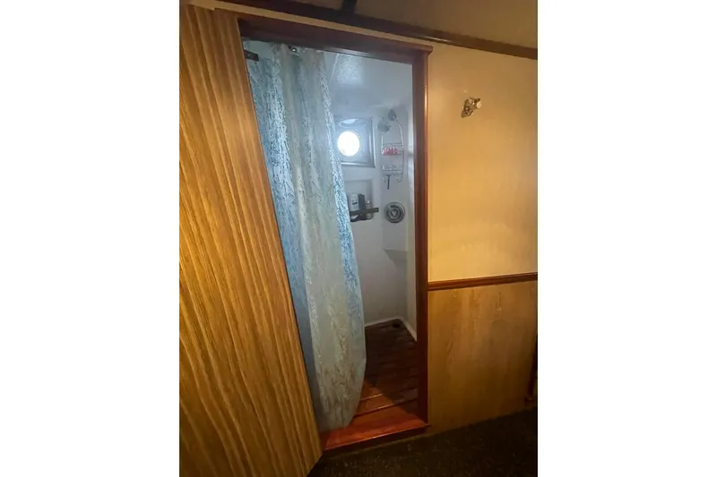 Slide: The Image of Interior view of 1973 Custom 58’ Steel Marco Seiner, featuring a wooden doorway and curtain. - 14