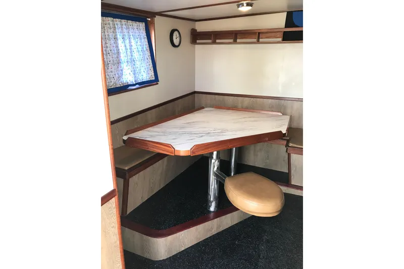 Slide: The Image of Interior of 1973 Custom 58’ Steel Marco Seiner with a cozy dining area and window. - 30