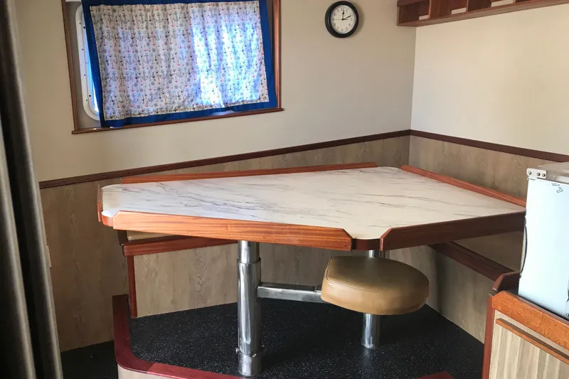 Slide: The Image of Dining area in a 1973 Custom 58’ Steel Marco Seiner with a triangular table and nautical decor. - 31