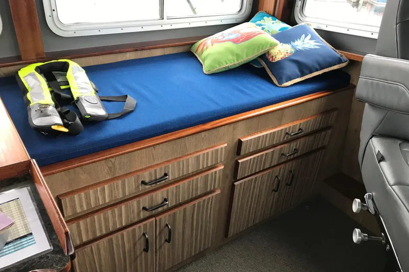 Slide: The Image of Interior of 1973 Custom 58’ Steel Marco Seiner with blue cushioned bench and life jacket. - 37