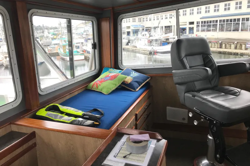 Slide: The Image of Interior of 1973 Custom 58’ Steel Marco Seiner with bed, chair, and marina view. - 7