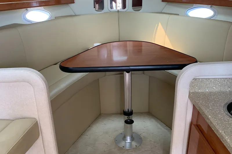 Slide: The Image of Interior of 2006 Rinker Fiesta Vee 300 boat with dining table and seating area. - 11