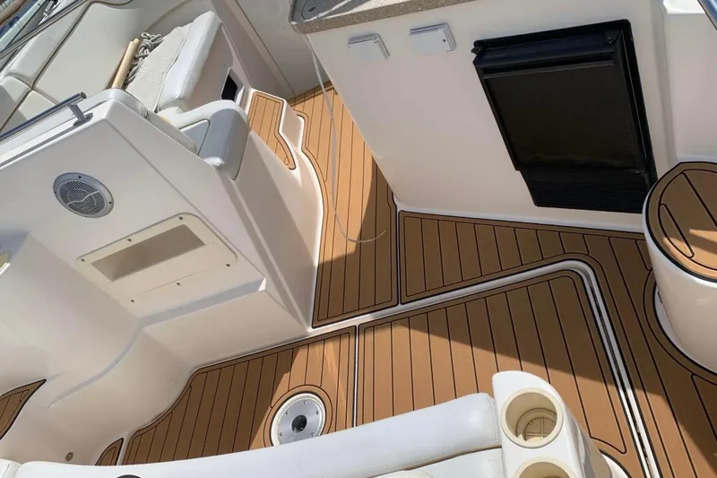 Slide: The Image of 2006 Rinker Fiesta Vee 300 boat interior with teak flooring and seating area. - 23