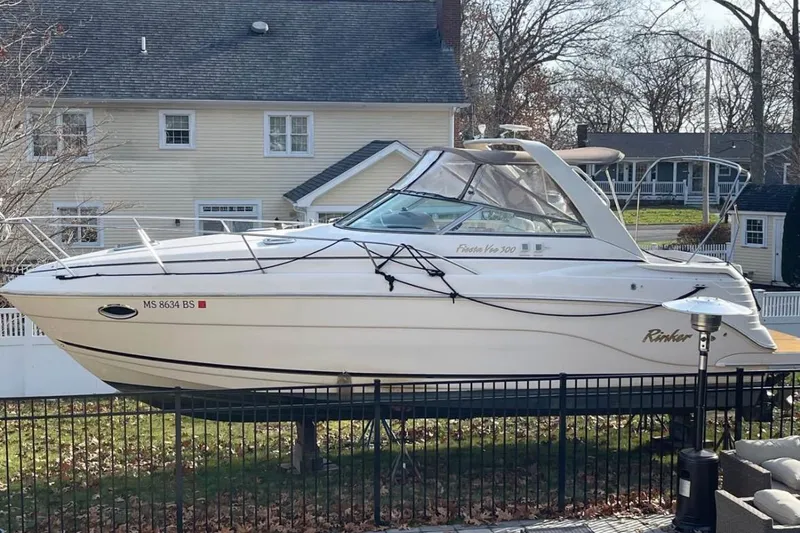 Slide: The Image of 2006 Rinker Fiesta Vee 300 boat on display in a residential yard. - 24