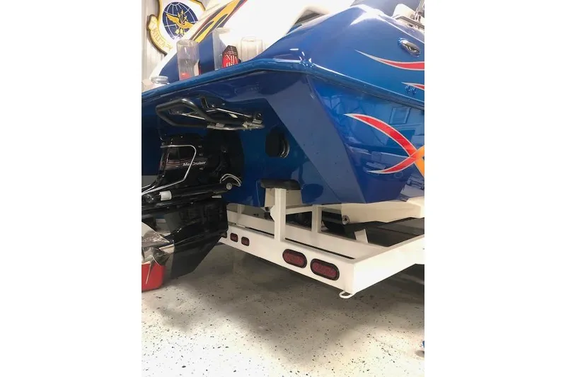 Slide: The Image of 2005 Conquest Top Cat boat with vibrant blue and red design on trailer. - 5