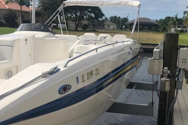 Slide: The Image of 2005 Conquest Top Cat boat docked, featuring sleek design and white seating. - 8