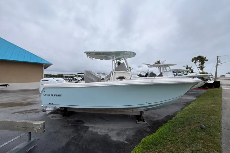 Slide: The Image of 2024 Sailfish 242 CC boat on display, light blue hull, overcast sky. - 1