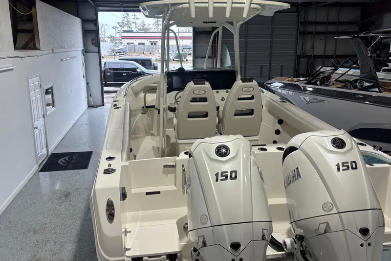 Slide: The Image of 2024 Sailfish 242 CC boat with dual Yamaha 150 engines in a showroom. - 7