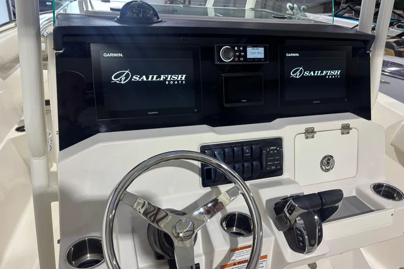 Slide: The Image of 2024 Sailfish 242 CC boat dashboard with Garmin displays and steering wheel. - 9